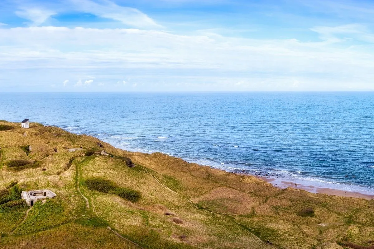 De kust van Noord-Jutland met begroeide duinen, een bunker en de Noordzee erachter